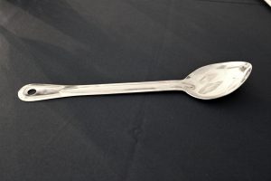 silver serving spoon on a black background