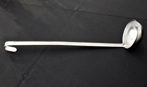 silver ladle on a black backgorund